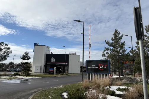 Automazgātuve ar nelielu ēku un zāli ziemas ainavā.