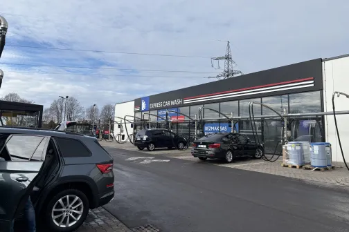 Automa&scaron;īnas pie automazgātavas zem mākoņainām debesīm.