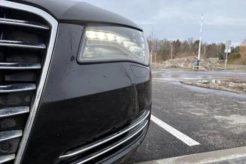 Melna automa&scaron;īna stāvvietā pelēkā, ziemīgā dienā.