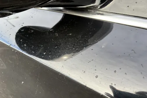 Melnas automa&scaron;īnas virsma ar ūdens pilienu pēdām.