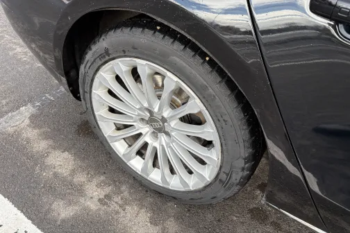 Melna automa&scaron;īna ar tīru, spīdīgu riteņa disku.