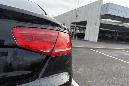 Melnas automa&scaron;īnas aizmugure stāvvietā pie autostāvvietas ēkas.