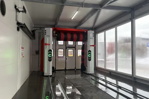 Automātiskā automazgātava ar sarkaniem un melniem birstes veltņiem.