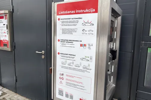 Ierīce ar automazgātavas instrukcijām, sarkanā un baltā krāsā.