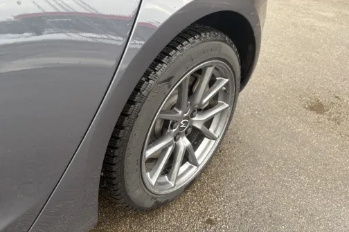 Auto aizmugurējā riteņa tuvplāns uz bruģa.