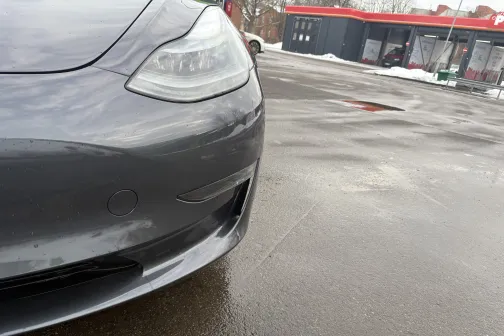 Sudraba krāsas auto priek&scaron;daļa pie automazgātavas ziemā.