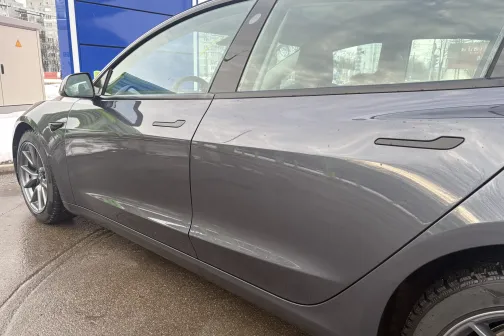 Pelēkas automa&scaron;īnas sānskats automazgātavā.