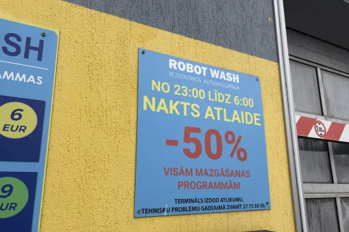Zīme pie automazgātuves ar nakts atlaidēm līdz 50%.