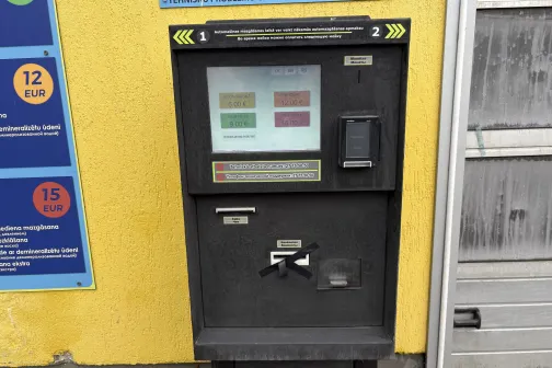 Automazgātuves maksājumu automāts uz dzeltenas sienas.