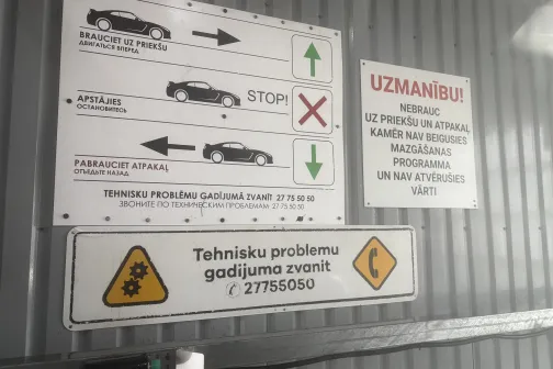Automazgātuves instrukcijas un brīdinājumi uz metāla sienas.
