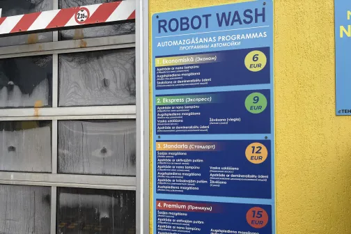 Robota mazgā&scaron;anas programmu saraksts pie dzeltenas sienas.