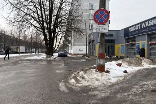 Uz ielas, ziemas dienā, auto mazgātava ar blakus eso&scaron;u ceļazīmi.