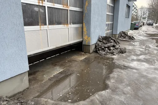 Automa&scaron;īnu mazgātavas durvis, peļķe un sniega kaudze priek&scaron;ā.