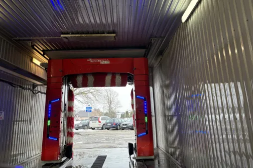 Automa&scaron;īnu mazgātavas izeja ar sarkanu vārtu un ārā redzamu ielu.