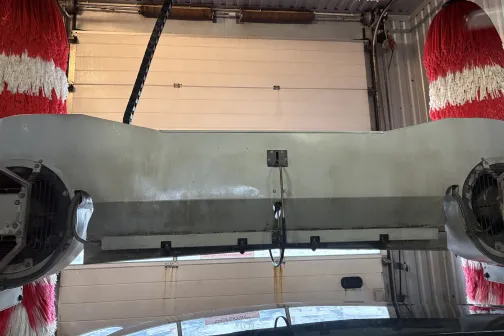 Automa&scaron;īnu mazgātuves iekārta ar sarkani baltiem birstēm.