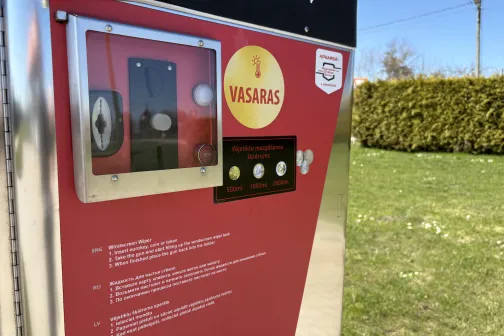 Sarkanās carwashas automāts saulainā dienā.