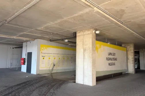 Mazgā&scaron;anas zona ar dzeltenu joslu uz sienām stāvvietu ēkā JT Carwash automazgātavā Rīgā