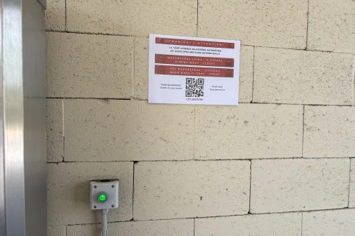 Zaļā vārtu poga un brīdinājums par automātiskajiem vārtiem mazgā&scaron;anas zonā PUTO automazgātavā Siguldā