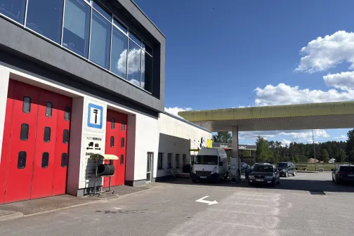Ēka ar sarkanām durvīm un informācijas zīmi pie Straujupīte automazgātavas Inčukalna pagastā