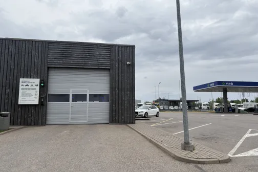 Vir&scaron;i automazgātavas ēkas aizmugure ar vārtiem un stāvlaukumu Riekstiņos