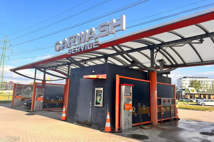 Pa&scaron;apkalpo&scaron;anās automazgātava saulainā dienā ar oranžiem akcentiem.