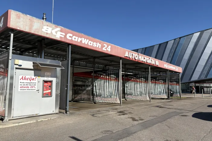 Automa&scaron;īnu mazgātava ar sarkanu uzrakstu un metāla konstrukcijām.