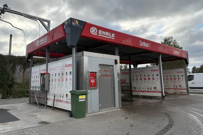 Āra automazgātava ar sarkanu jumtu un logos.