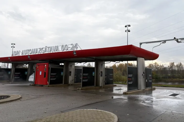 Automazgātava ar vairākām stacijām zem mākoņainām debesīm.