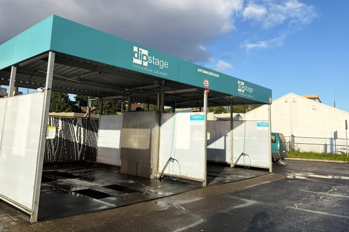 Automa&scaron;īnu mazgātuve skaidrā dienā ar zilu debesu fonu.