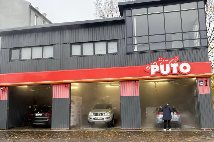 Automazgātava ar vairākiem vārtiem zem mākoņainām debesīm.