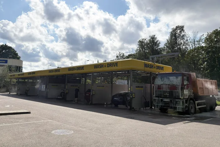 Automa&scaron;īnu mazgātava ar vairākām stacijām, blakus smagā automa&scaron;īna.