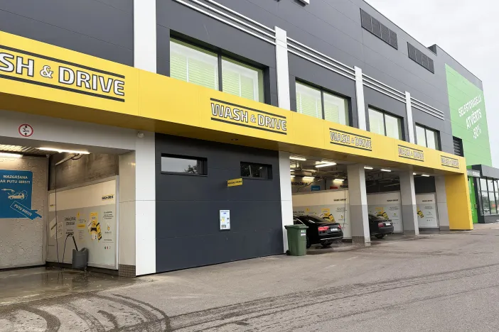 Automa&scaron;īnu mazgātuve ar dzeltenām izkārtnēm un dažām automa&scaron;īnām pie stacijām.