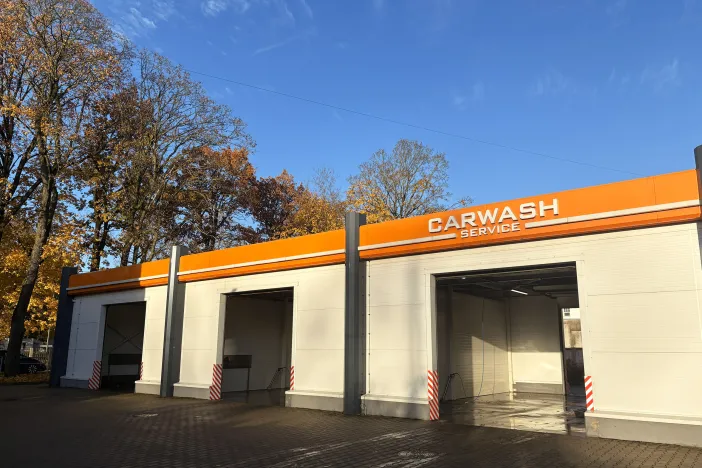 Oranža automa&scaron;īnu mazgātuve ar atvērtām druvīm.