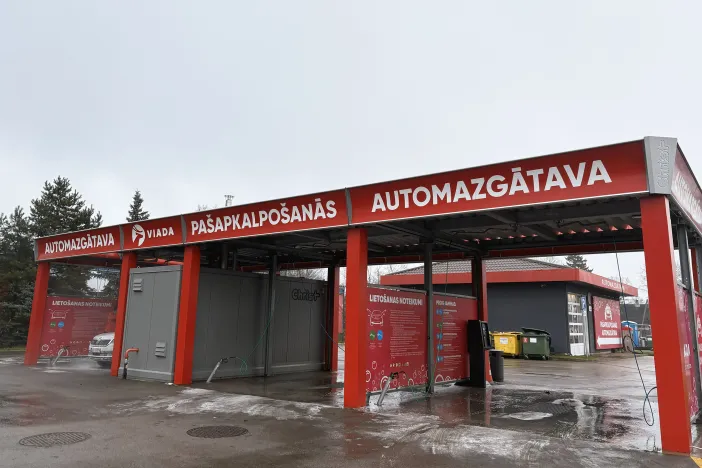 Automazgātava ar sarkaniem akcentiem un uzrakstiem.