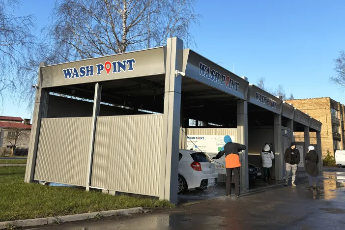 Automazgātava saulainā dienā, vairākas automa&scaron;īnas tiek mazgātas.