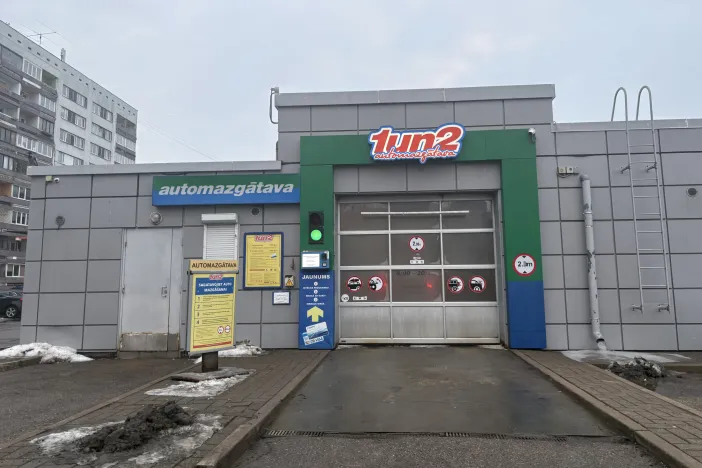 Automazgātuves ēka ar durvīm un zīmēm pie ieejas.