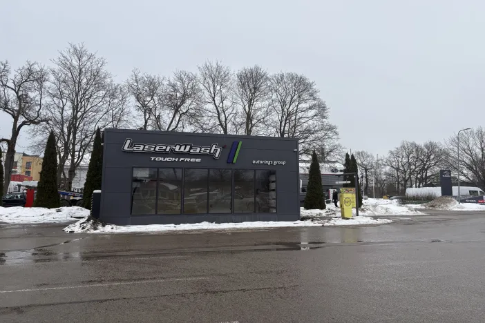 Automazgātava ziemas laikā, pelēcīga debess un sniegotas malas.