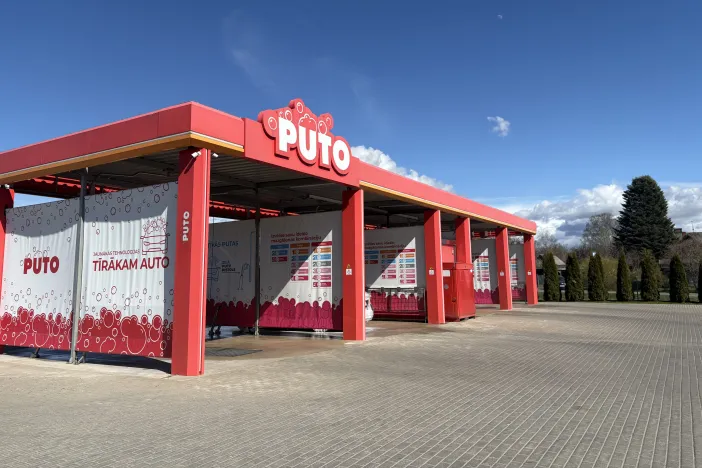 PUTO Auto mazgātava saulainā dienā, sarkanas un baltas krāsas toņi.